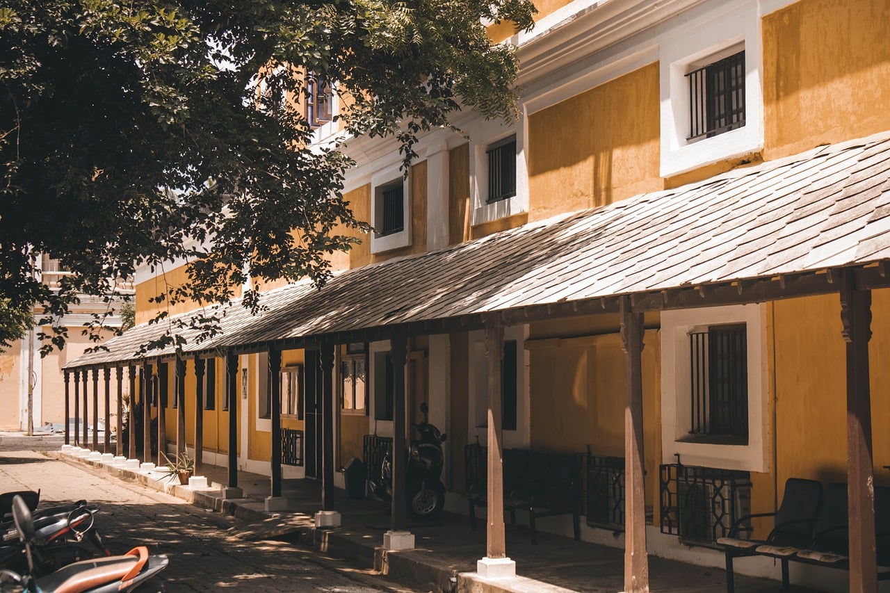 An ochre-walled White Town street in Pondicherry’s French Quarter, with a tiled colonial veranda.
